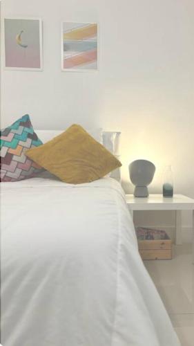 a white bed with a pillow and a table at GroveO5 10 minutes from Miami Beach in Miami