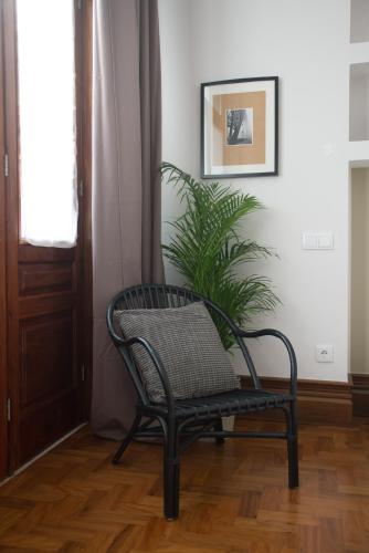 a black chair in a room with a plant at Nidos Accommodation Gaia in Vila Nova de Gaia