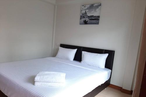 a white bed with two pillows on top of it at Phenwaree Amphawa Resort in Ban Dao Dong