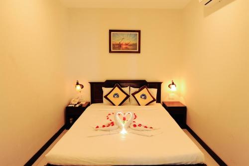 a bedroom with a bed with a heart decoration on it at Cuu Long Hotel in My Tho