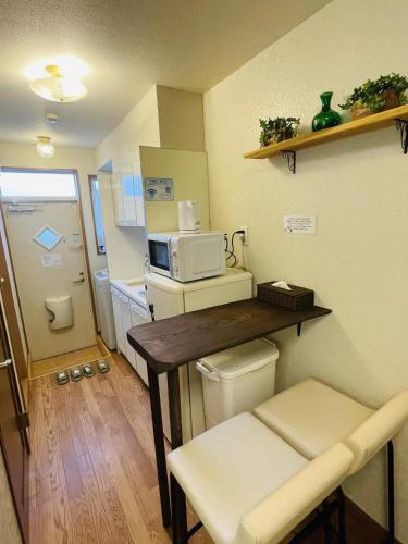 a small kitchen with a table and a microwave at Yokohama Ivy 103 - 横浜アイビー清水ヶ丘103 - in Yokohama