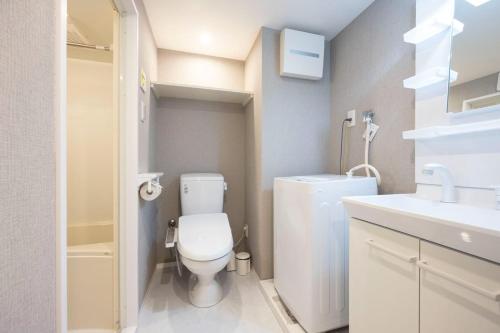 a small bathroom with a toilet and a sink at ARUCIA Sangenjaya in Tokyo