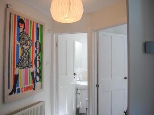 a bathroom with a painting of a woman on the wall at 2 Court Cottages in Kingsbridge