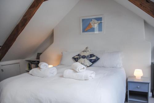 a white bed with towels on top of it at 2 Court Cottages in Kingsbridge