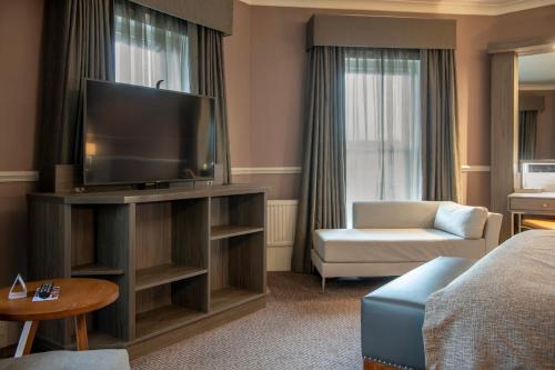 a hotel room with a television and a couch at Crowne Plaza - Sheffield by IHG in Sheffield