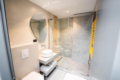 a bathroom with a shower and a toilet and a sink at Mandachi Hotel & SPA in Suceava
