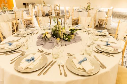 a table set for a wedding with white table settings at Holiday Inn Newcastle Gosforth Park by IHG in Newcastle upon Tyne