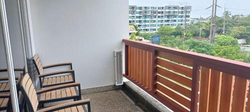 two chairs sitting on a balcony with a view of a building at DARA Hotel - SHA Plus in Phuket Town