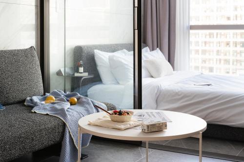 a room with a bed and a coffee table and a couch at Le Collective Gangnam SAC Roium in Seoul