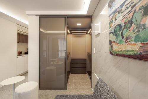 a hallway with a glass door leading to a bathroom at Le Collective Gangnam SAC Roium in Seoul
