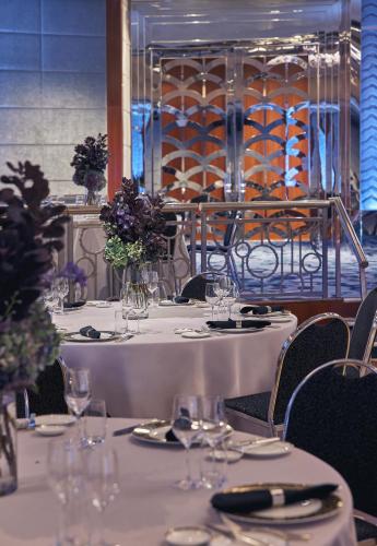 a set of tables with glasses and flowers on them at Park Hyatt Melbourne in Melbourne
