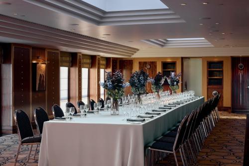 a long table in a room with chairs and flowers at Park Hyatt Melbourne in Melbourne