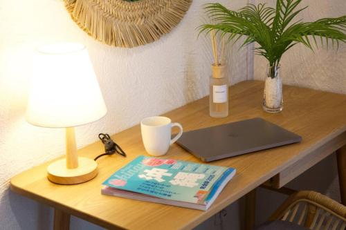 a desk with a laptop and a lamp and a book at 崎本部戸建プール付き g棟 in Motobu