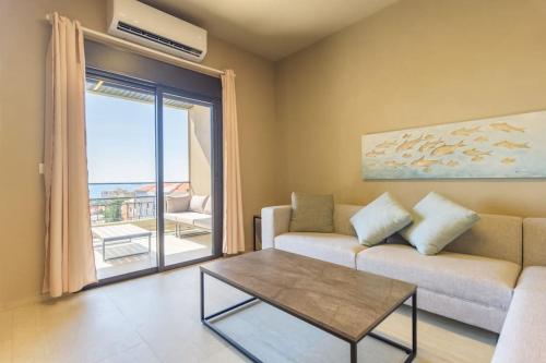a living room with a couch and a table and a window at Soukside Haven 3BR 24-7 Electricity in Batroûn