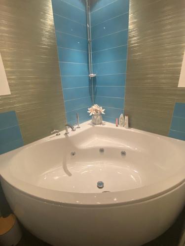 a white tub in a bathroom with blue tiles at bei Tante Tina in Bad Bergzabern
