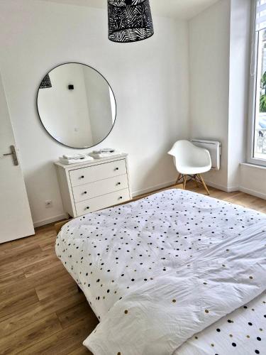 - une chambre avec un lit, un miroir et une commode dans l'établissement La Capucine, à Coulommiers