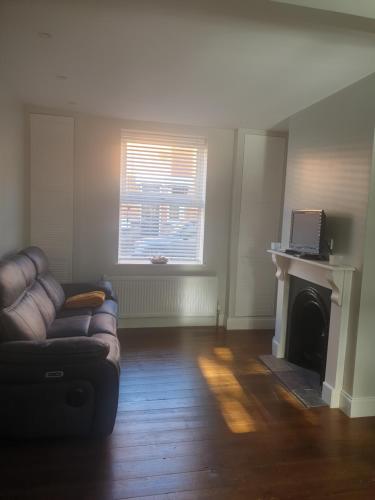 a living room with a couch and a fireplace at Rushden small double room in Rushden