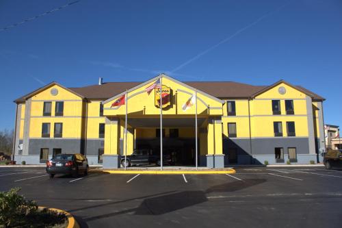 a yellow building with a car parked in a parking lot at Super 8 by Wyndham Crossville TN in Crossville