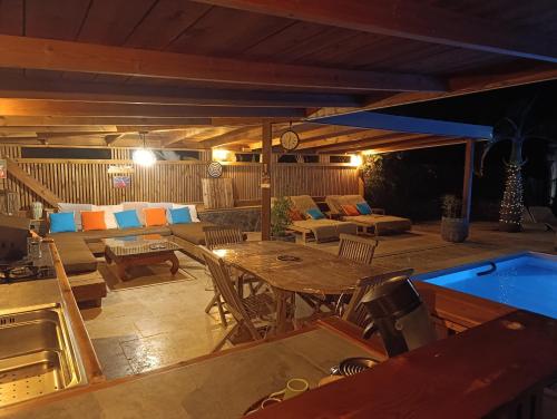 a large patio with a table and a couch at Villa Baies Roses in Saint-Leu