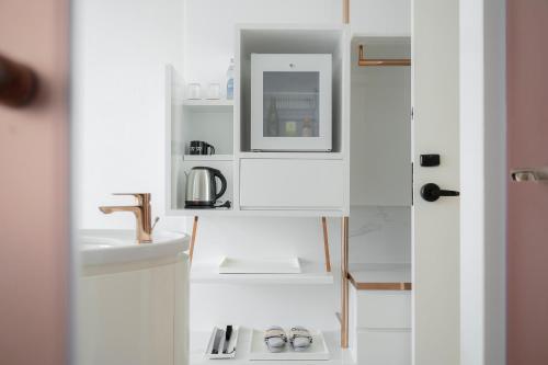 a white bathroom with a sink and a mirror at INNSiDE by Meliá Bangkok Sukhumvit in Bangkok