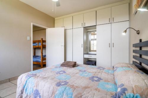 a bedroom with a large bed and white cabinets at ATKV Natalia in Kingsburgh