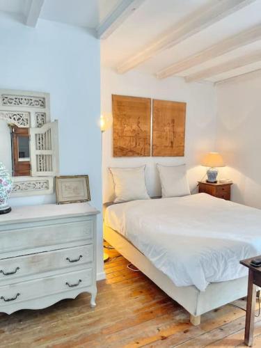 a bedroom with a white bed and a dresser at Maison bucolique champs de blé in Villers-Agron-Aiguizy