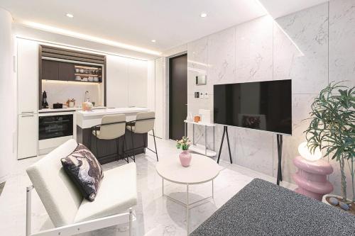 a living room with a kitchen and a television at Le Collective Gangnam SAC Roium in Seoul