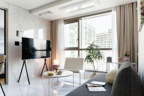 a living room with a couch and a tv at Le Collective Gangnam SAC Roium in Seoul