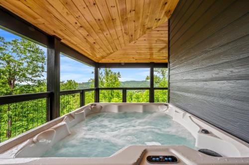 einen Whirlpool in einem Haus mit Fenstern in der Unterkunft Smoky Bear Vista Brand New Luxury Cabin One Mile from Downtown Gatlinburg in Gatlinburg