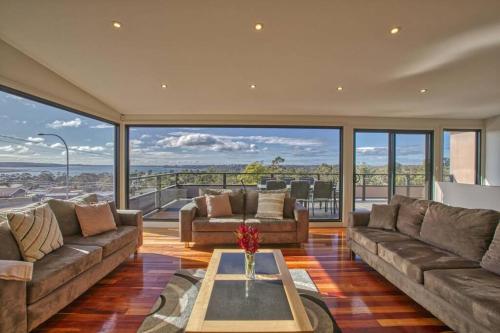 a living room with couches and a table at Georges Bay Luxury in St Helens