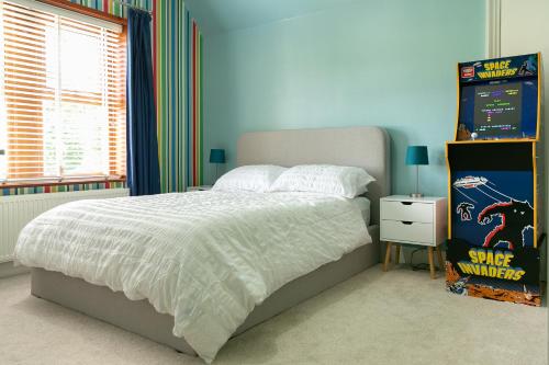 a bedroom with a bed and a video game at Modern Family Home - Gateway to Yorkshire in Leeds