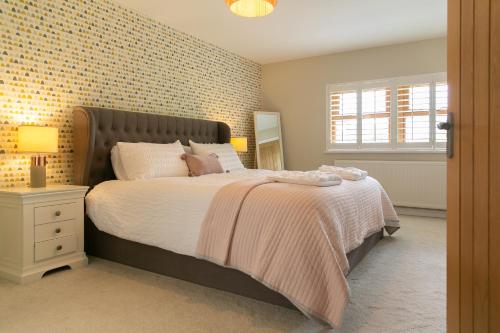 a bedroom with a large bed and a window at Modern Family Home - Gateway to Yorkshire in Leeds