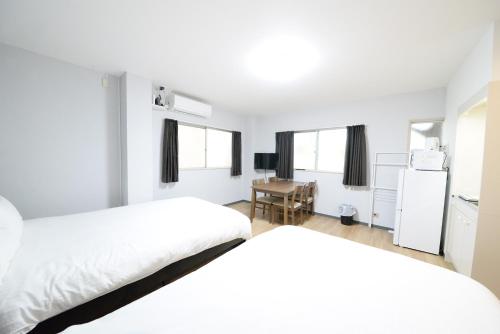 a bedroom with two beds and a desk in it at 和の楓cottage第二202 新宿歌舞伎町近隣 in Tokyo