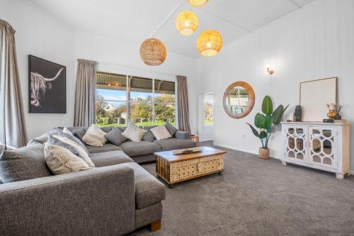 a living room with a couch and a table at The Olive Corner- Martinborough Holiday Home in Martinborough 