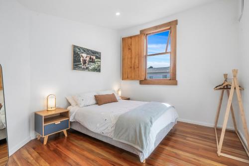 a bedroom with a bed and a window and a tripod at The Olive Corner- Martinborough Holiday Home in Martinborough 