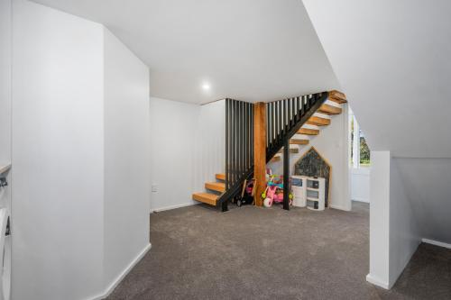 an attic room with a staircase and a play area at The Olive Corner- Martinborough Holiday Home in Martinborough 