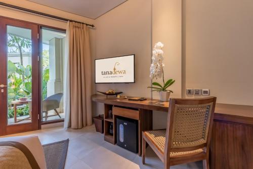 a living room with a desk and a tv at tanadewa Resort Ubud Bali by Cross Collection in Ubud