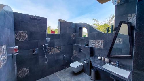 a bathroom with a toilet and a sink and a mirror at Tathastu Tadoba in Mohurli