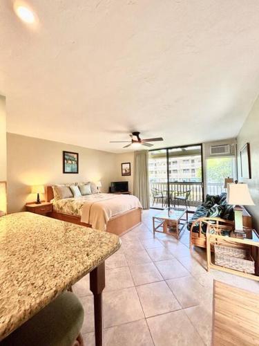 a large bedroom with two beds and a balcony at Amazing condo peaks of ocean view On Ali'i Dr by surf spots in Kailua-Kona
