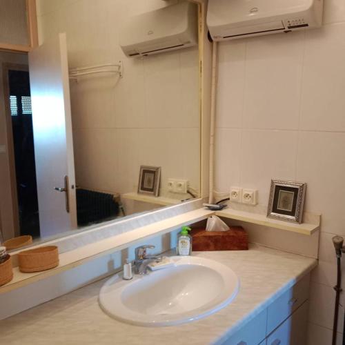 une salle de bain avec un lavabo et un grand miroir dans l'établissement Appartement T2 face Mer, moderne, clim, parking 4NOUM6, à Canet