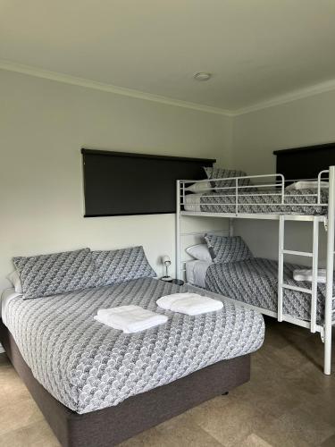 a bedroom with a bed and two bunk beds at Buchan Motel in Buchan