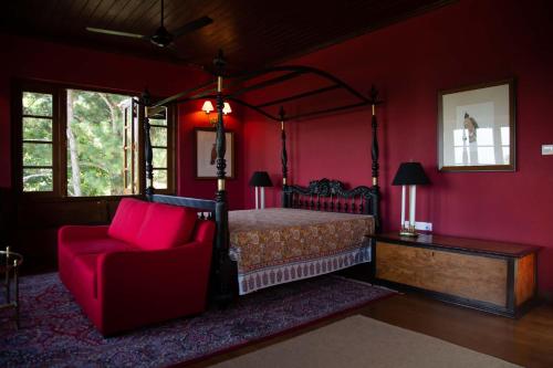 a red bedroom with a bed and a chair at Kandy Dendrobium House in Kandy