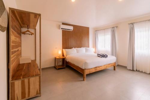 a bedroom with a white bed and a mirror at Hotel Santa Teresa by the Beach in Santa Teresa Beach