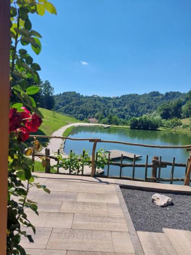 a view of a lake with a fence and a bench at Zelena Oaza in Zgornja Kungota