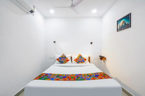 a white room with a bed with colorful sheets at FabHotel VKs - Nr UMCC Shahpur, Jeedimetla in Hyderabad