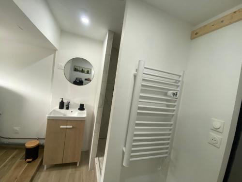 une salle de bain blanche avec un lavabo et un miroir dans l'établissement Maison proche de la mer, à Campagne-lès-Hesdin