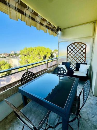 une table bleue et des chaises sur un balcon dans l'établissement Escapade Méditerranéenne, à Cagnes-sur-Mer