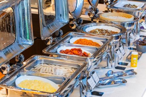 a buffet line of trays of food on a table at Hotel Lifort Sapporo in Sapporo