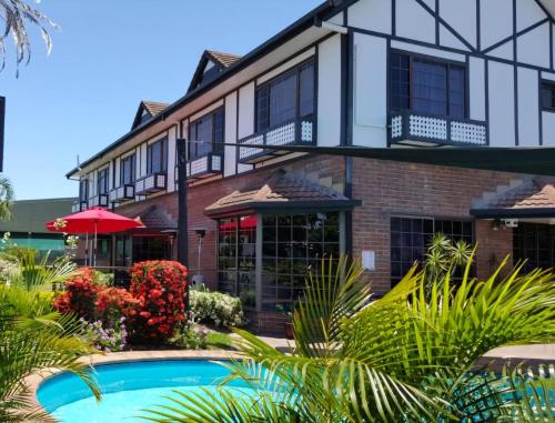 a house with a swimming pool in front of it at Shakespeare Motel in Mackay