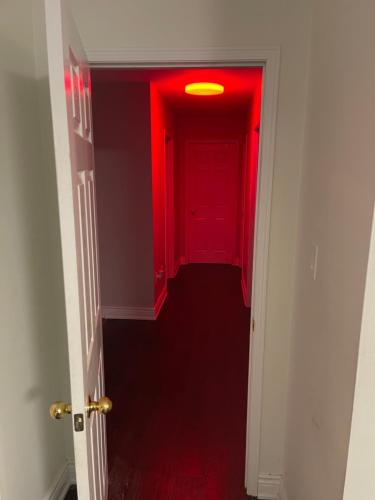 a hallway with a red door and a red light at Finesse in Whitby